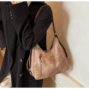 Close-up of khaki retro tote bag with frosted leather texture and silver fashion plaque