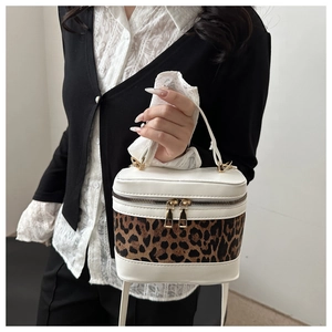 Detail of trendy leopard print patchwork mini bag with golden dual zippers and top handle
