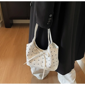 Gros plan du sac blanc avec nœud en jacquard texturé et motifs d'oiseaux noirs