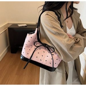 Sac fourre-tout texturé rose et noir avec un nœud et des lanières en cuir verni