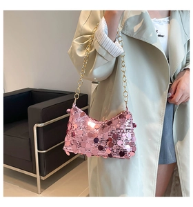 Detail of pink sequin handbag with thick gold metal chain and reflective surface