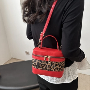 Retro bucket bag with red glossy finish and leopard print panels on white background