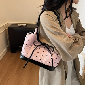 Sac à bandoulière rose à imprimé nœud avec base en cuir noir et tissu texturé chic