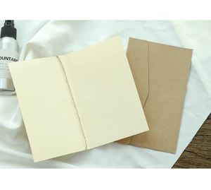 Minimalist cream greeting card with twine bow and brown kraft envelope on fabric