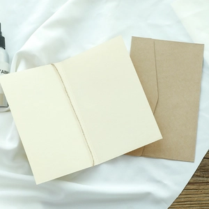 Minimalist vintage greeting card with kraft envelope and decorative twine on white fabric