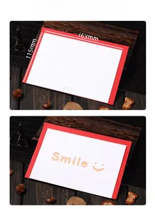 Detail of laser-cut Smile greeting card with red envelope on a vintage wooden desk