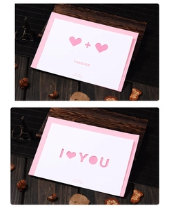Detail of hollowed-out double hearts and I Love You text on card with pink envelope