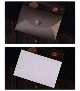 Detail of pearlescent paper envelopes with heart-shaped closures on rustic wood