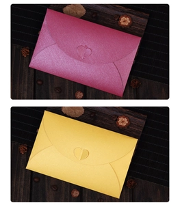Detail of pearlescent pink and gold envelopes with heart-shaped clasps and metallic texture