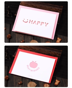 Detail of laser-cut greeting cards with Happy and Best Wishes hollow designs on wood