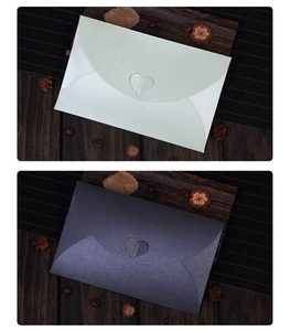 Close-up of pearl paper envelopes with heart-shaped clasps in light green and dark grey