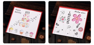 Detail of hollowed-out birthday and greeting cards with red lining on dark wood table