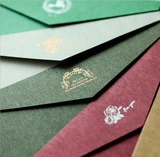 Macro shot of textured multi-color envelopes with gold foil and rose patterns