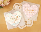 Macro view of heart-shaped gift tags with Love You and Thank You gold lettering