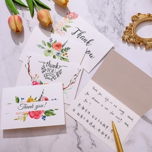 Elegante set bedankkaarten met bloemen en goudfolie op marmeren achtergrond