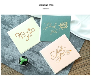 Detail of square bronzing thank you cards in off-white, dark green, and light pink colors