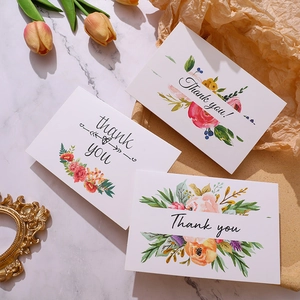 Detailopname van elegante aquarel bloemen bedankkaarten op marmeren achtergrond
