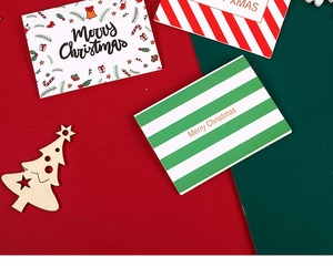 Detail view of mini Christmas cards and wooden tree ornament on red and green background