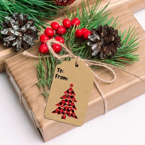 Close-up of kraft paper Christmas gift tags with plaid tree pattern on gift wrapping