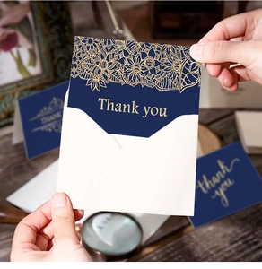 Detailed view of dark blue thank you card with gold foil mandala and matching envelope