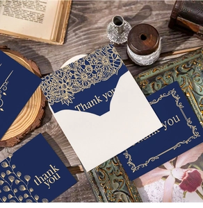Detailed view of dark blue thank you card with gold foil patterns and matching envelope