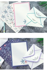 Detail of floral stationery set with patterned envelopes and lined paper on stone surface
