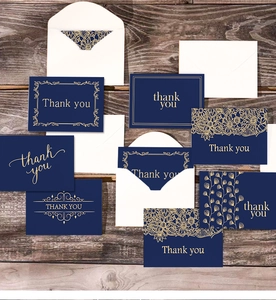 Detail of dark blue thank you cards with gold foil patterns and matching white envelopes