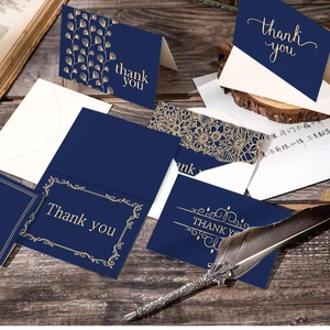 Navy blue and gold foil thank you card set with envelopes on a rustic wooden desk