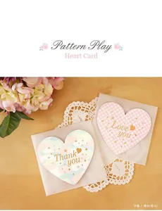 Detailed view of Cloud and Pink Check heart cards with frosted envelopes on a wooden table