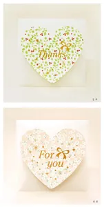 Detailed view of heart-shaped cards with berry and floral patterns with white envelopes