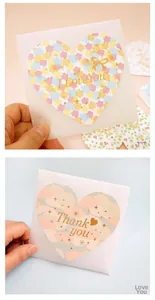 Detail of mini greeting card envelopes with floral heart stickers and gold typography