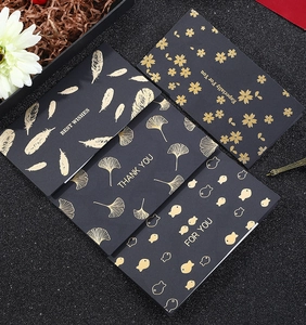 Detail view of four elegant black cards with gold foil patterns and best wishes text
