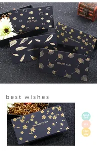 Detail of gold foil stamped black greeting cards with fish and feather motifs on heavy paper
