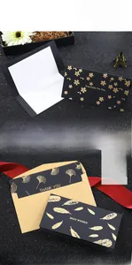 Detail of black gold foil thank you cards featuring floral motifs and kraft envelopes