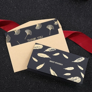 Black gold foil greeting cards with Ginkgo leaves and envelopes on black glitter background