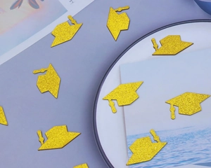 Macro detail of gold glitter graduation cap confetti on a blue aesthetic background