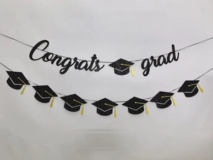 Detail of Congrats Grad glitter banner with gold tassels and black mortarboard caps