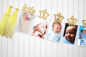 Detail of gold glitter star photo clips and Just Born banner for baby birthday