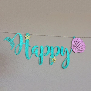 Glittering mermaid Happy Birthday banner with teal letters, fish tails, and shells