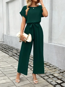 Close-up detail of dark green wide-leg jumpsuit with drawstring waist and soft texture