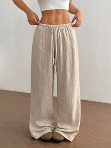 Detail der elastischen Taille und des strukturierten Krepp-Stoffes der beigen weiten Hose