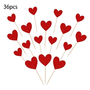 Vista macro de 36 adornos de pastel corazón con purpurina roja y palos de madera