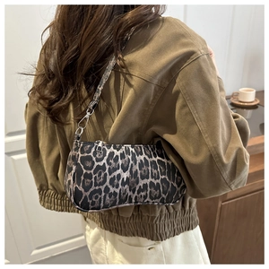 Detail of trendy leopard print shoulder bag with plush texture and silver metal hooks