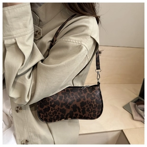 Detail der Leopard-Unterarmtasche kombiniert mit beigem Trenchcoat für Herbstmode