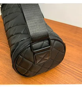 Detail of custom metal hardware and durable quilting on black nylon cylinder bag