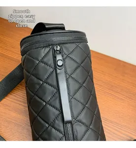Detail of smooth black quilted nylon cylinder bag featuring high-quality zippers