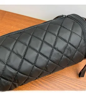 Macro detail of black quilted cylindrical bag showing high-quality waterproof nylon fabric