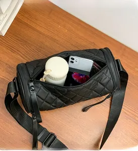 Interior view of black quilted cylinder bag showing storage space for phone and wallet