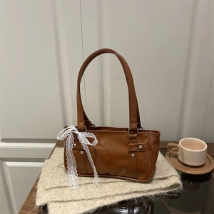 Brown faux leather shoulder bag with chic white lace bow and silver rivet accents