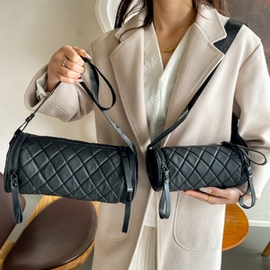Detail of two black quilted nylon cylinder bags in large and small sizes for comparison